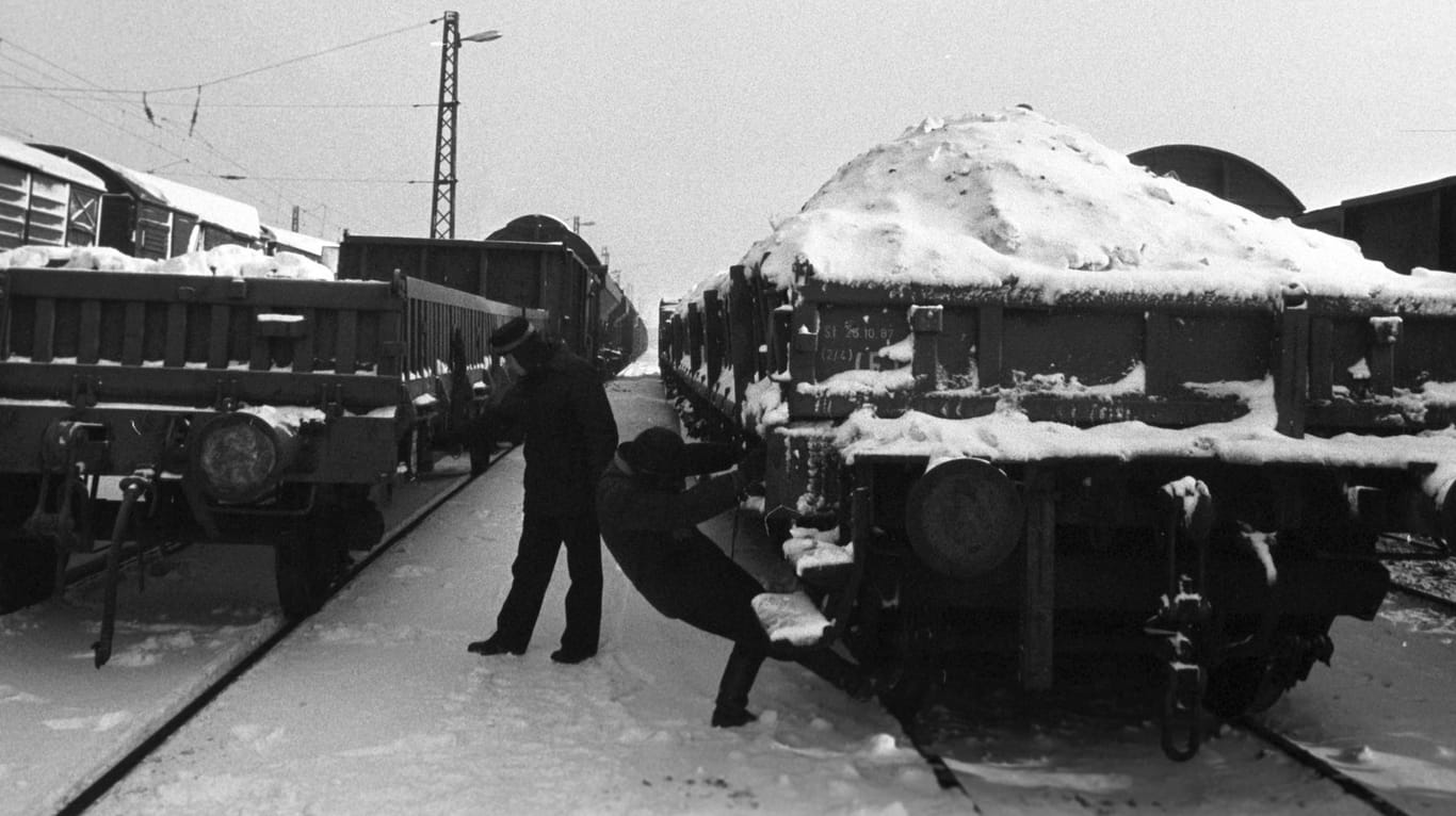 Beim Kälteeinbruch im Januar 1987 in Leipzig bemühen sich Mitarbeiter der Deutschen Reichsbahn, die eingeschneiten Güterwagen wieder fahrbereit zu machen.