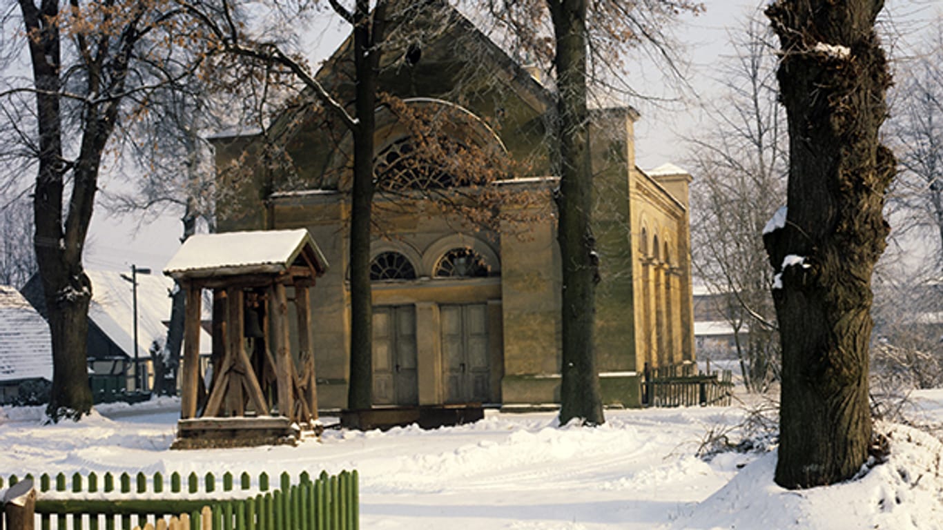 Blick auf die im klassizistischen Stil errichtete Dorfkirche von Annenwalde bei Templin, aufgenommen im Winter 1987.