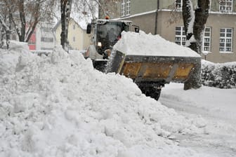 Ein Bagger befreit die Straßen vom Schnee.