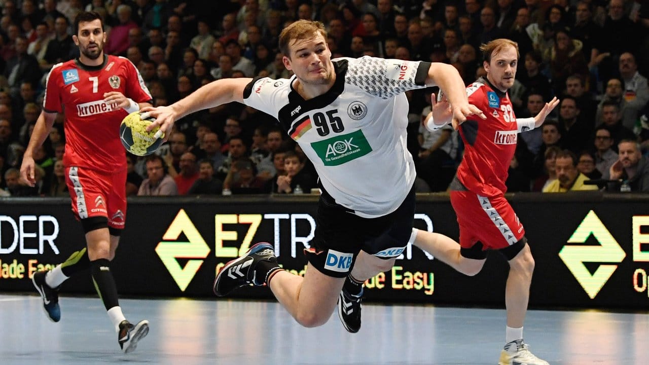 Deutschlands Paul Drux (M) kommt zu einem Sprungwurf auf Österreichs Tor. Deutschlands Paul Drux (M) kommt zu einem Sprungwurf auf Österreichs Tor.