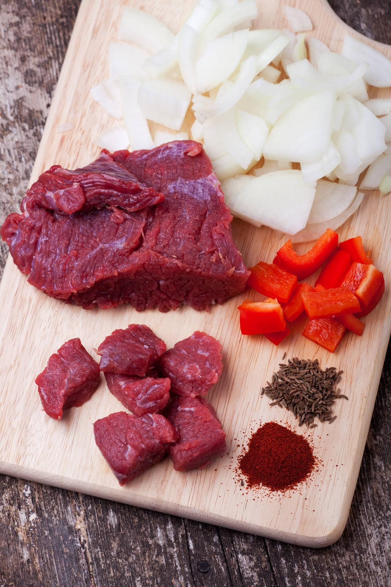 Neben Fleisch, sind Zwiebeln und Paprikapulver die typischen Zutaten für ein ungarisches Gulasch.
