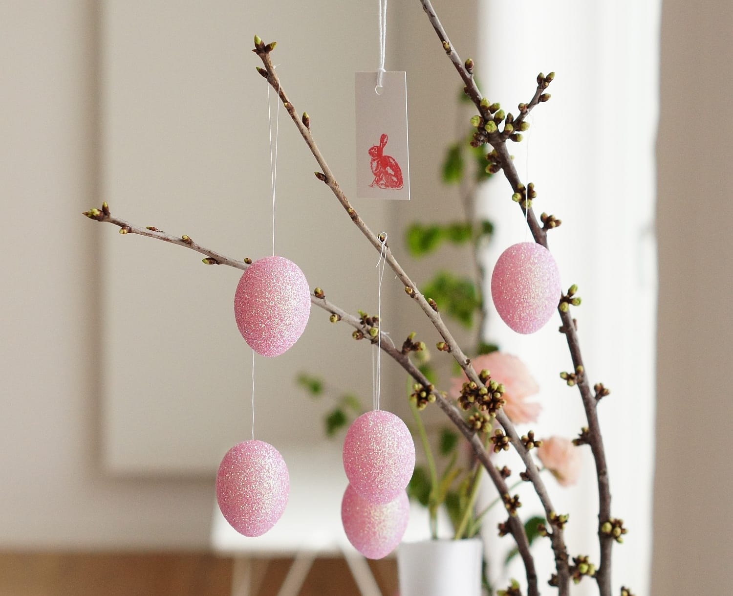 Langstielige Zweige mit ersten, grünen Knospen bringen die rosa eingefärbten Eier besonders effektvoll zur Geltung - und dazu noch den Frühling ins Haus.