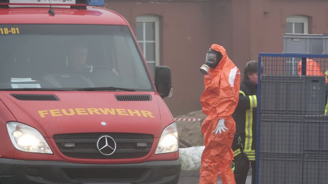 Ein Feuerwehrmann im Schutzanzug steht in der Nähe von Steinburg vor einer Geflügelzucht.