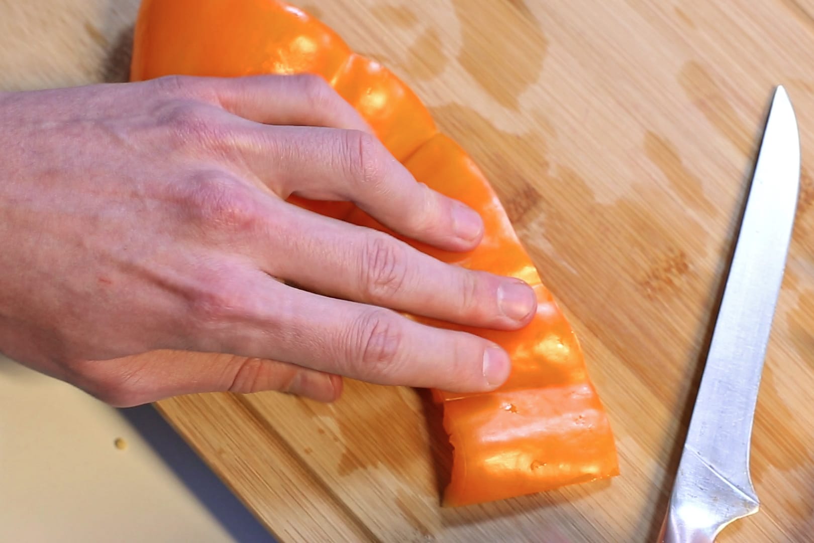 Schritt 5: Die entkernte Paprika kann man nun flach auf das Brett drücken und dann in Streifen oder Würfel schneiden.