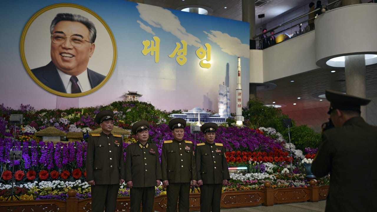 Wie befohlen: Armeeangehörige posieren vor einem Porträt von Staatsgründer Kim Il Sung. Wie befohlen: Armeeangehörige posieren vor einem Porträt von Staatsgründer Kim Il Sung.