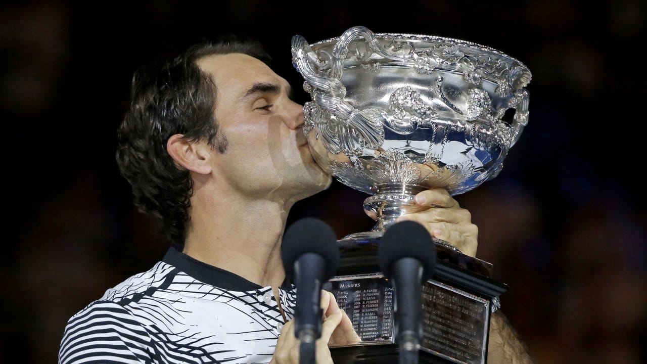 Roger Federer küsst die Trophäe der Australian Open.