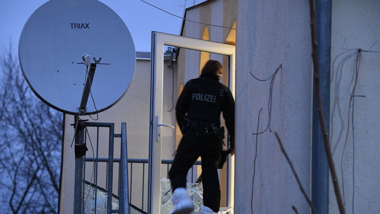 Ein Polizist betritt an der Rückseite die Bilal Moschee.