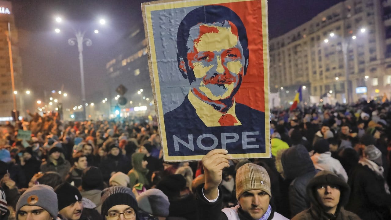 Ein Demonstrant hält eines Protests ein Plakat mit dem Porträt von Liviu Dragnea, dem Vorsitzenden der Sozialisten (PSD), in die Höhe.