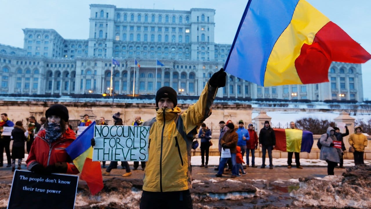 Demonstranten stehen in Bukarest vor dem Parlamentspalast.