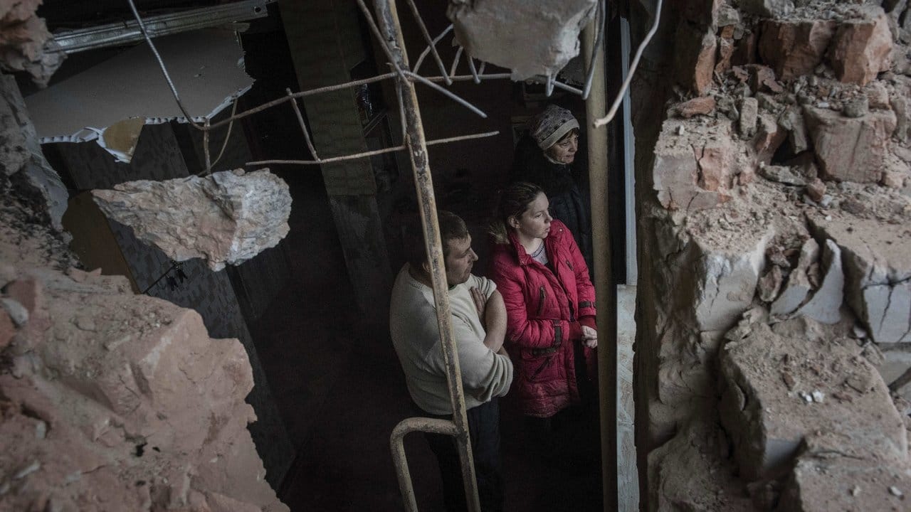 Zerbombt: Roman und Olga Duschikow schauen durch ein Fenster ihrer von Grananten zerstörten Wohnung in Awdijiwka in der Ostukraine.