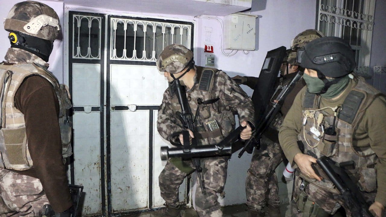 Türkische Polizisten einer Anti-Terror-Einheit brechen in Adiyaman eine Tür auf.