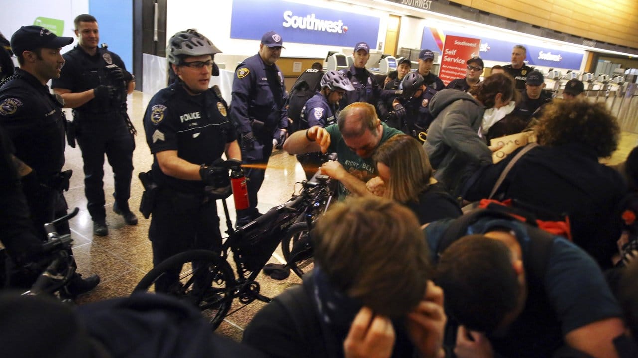 Bei Auseinandersetzungen mit Demonstranten setzten Polizisten am Flughafen von Seattle-Tacoma Pfefferspray ein.