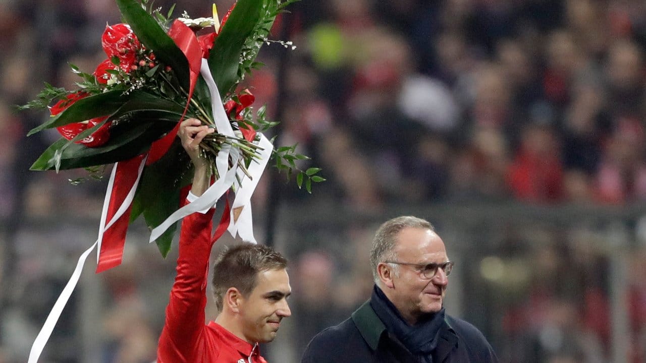 Philipp Lahm (l) erhält von Bayern-Vorstandschefs Karl-Heinz Rummenigge nachträglich Blumen für sein 500.