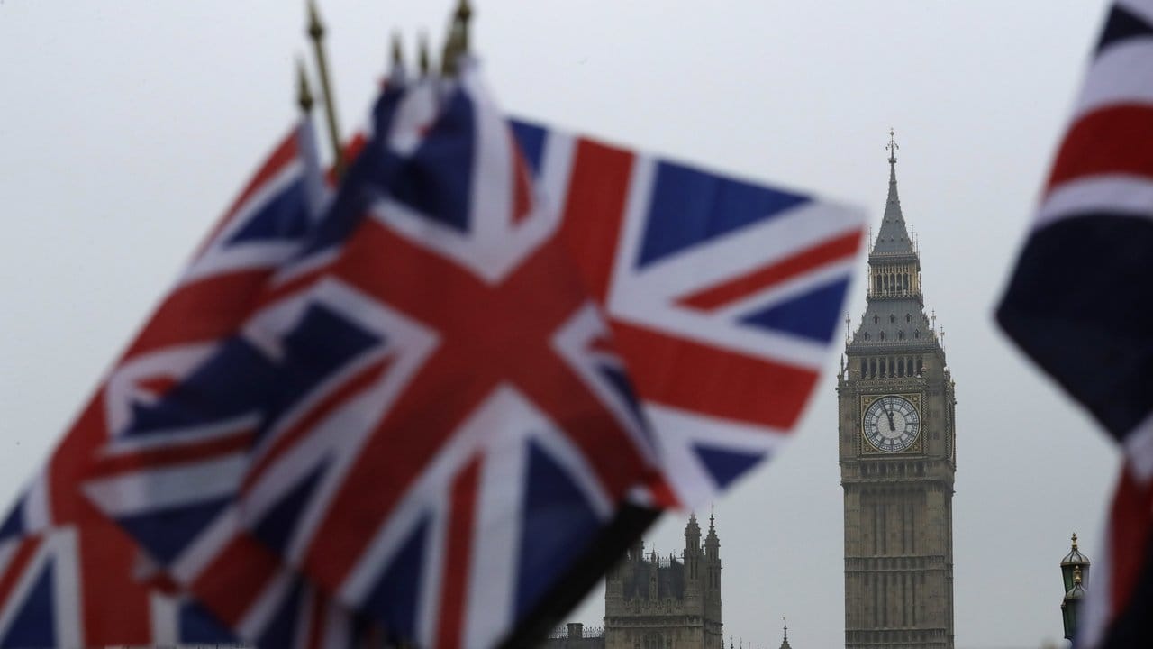 In der Nähe des berühmten Uhrturms Big Ben in Londen wehen britische Flaggen.