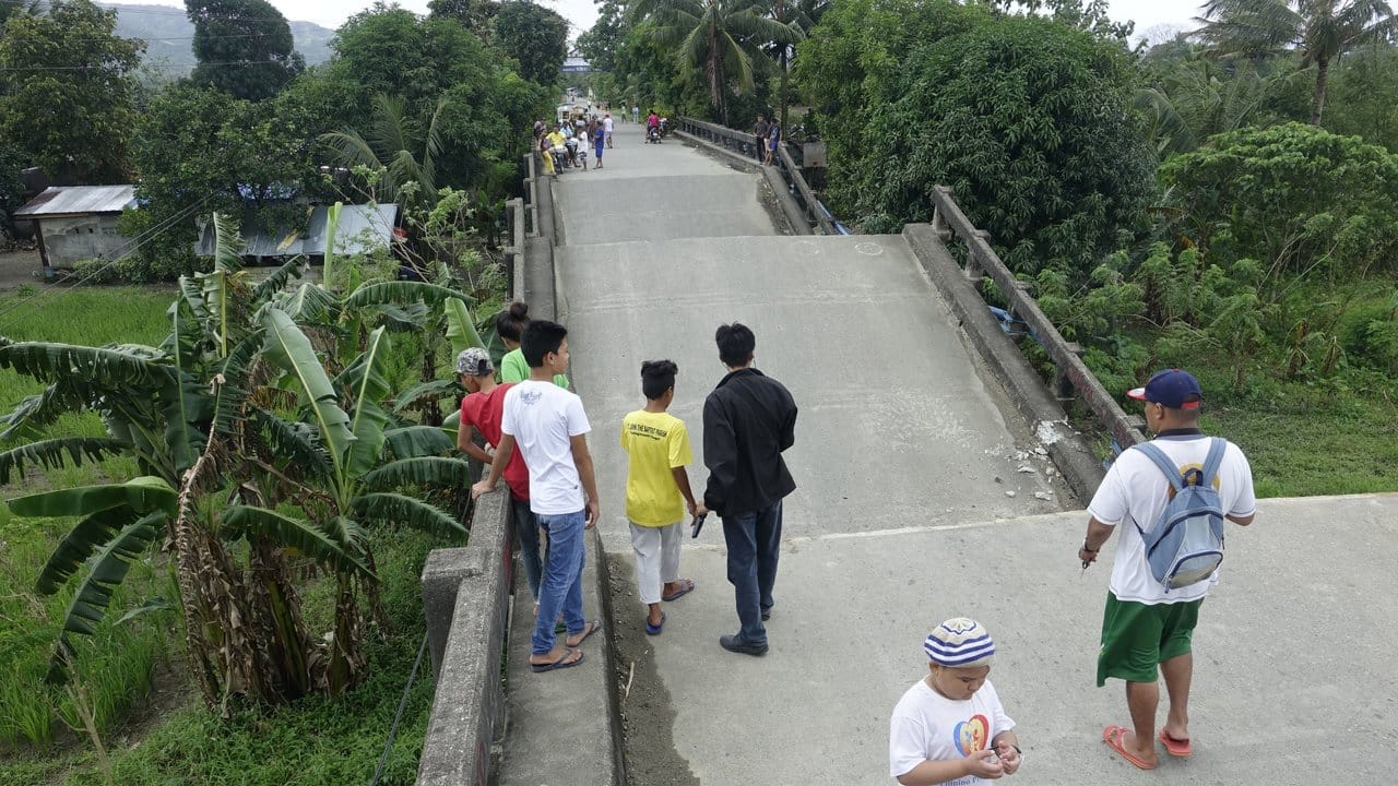 Anwohner stehen an einer teilweise zusammengestürzten Brücke in Surigao.