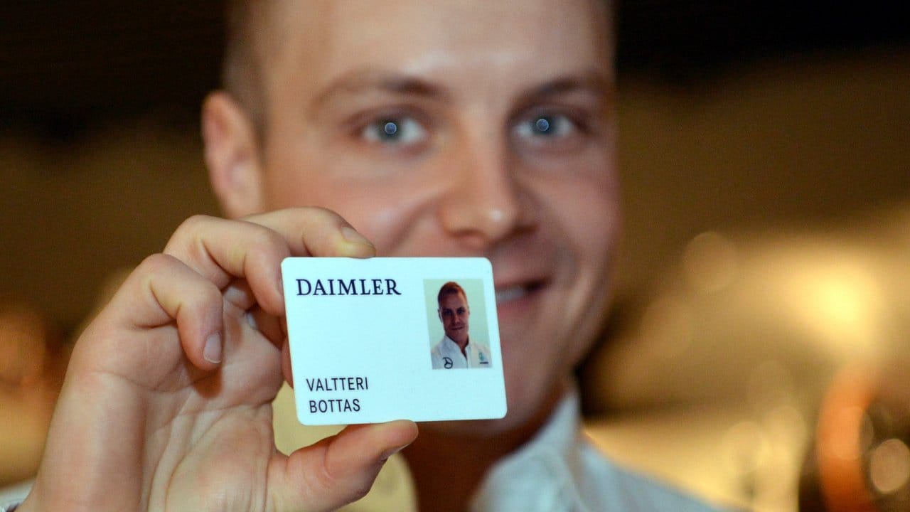 Der neue Mercedes-Fahrer Valtteri Bottas zeigt in Stuttgart seinen Daimler-Mitarbeiterausweis.