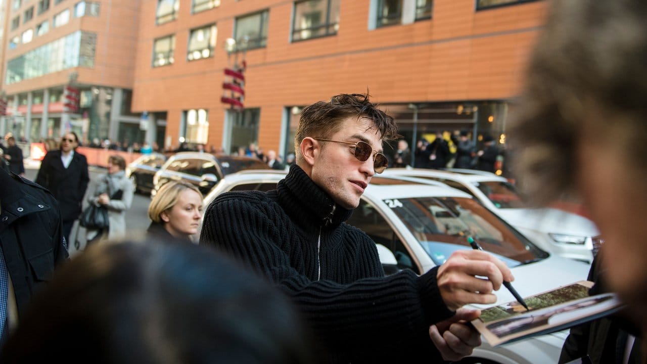 Der Schauspieler Robert Pattinson gibt Autogramme.