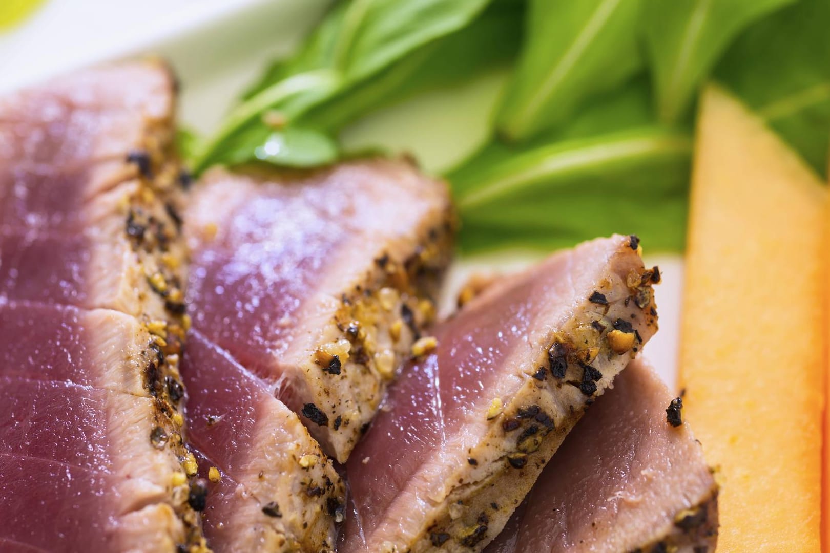 Scheiben eines Thunfischsteaks: Das gebratene Thunfischsteak ist außen knusprig und innen rosa.