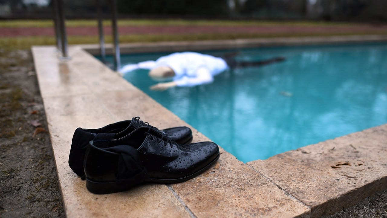 Vor dem Pool: ordentlich zusammengestellte Schuhe.
