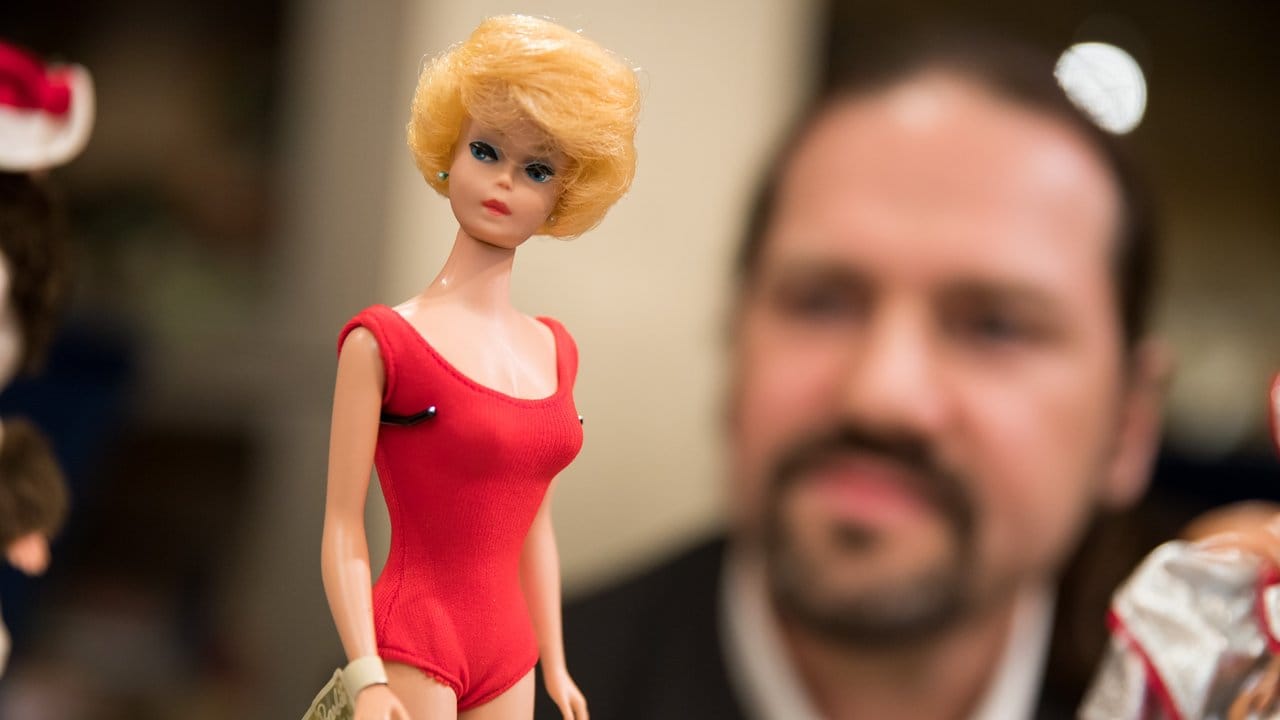 Wie erhält man ihren jugendlichen Schmelz? Chemie-Professor Jens schaut sich im Spielzeugmuseum in Nürnberg eine historische Barbie-Puppe von 1962 an.