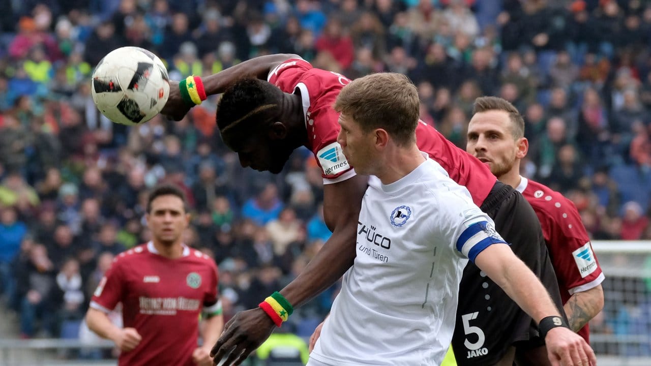 Hannovers Salif Sané (l) und Bielefelds Fabian Klos kämpfen um den Ball.
