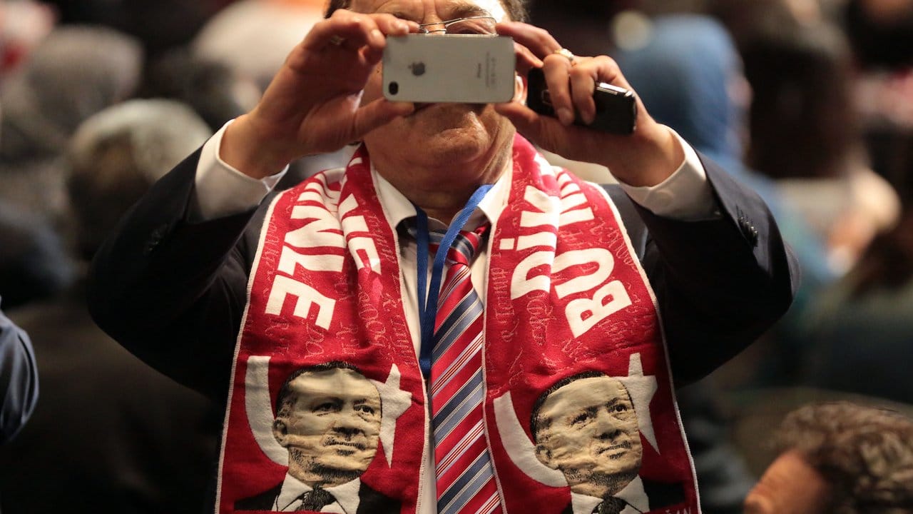 Ein Erdogan-Anhänger fotografiert im Mai 2014 in Köln den Auftritt des türkischen Regierungschefs Erdogan. Ein Erdogan-Anhänger fotografiert im Mai 2014 in Köln den Auftritt des türkischen Regierungschefs Erdogan.