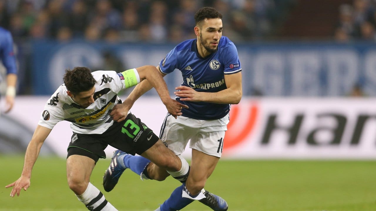Schalkes Nabil Bentaleb (r) und der Gladbacher Lars Stindl kommen beim Kampf um den Ball zu Fall. Schalkes Nabil Bentaleb (r) und der Gladbacher Lars Stindl kommen beim Kampf um den Ball zu Fall.