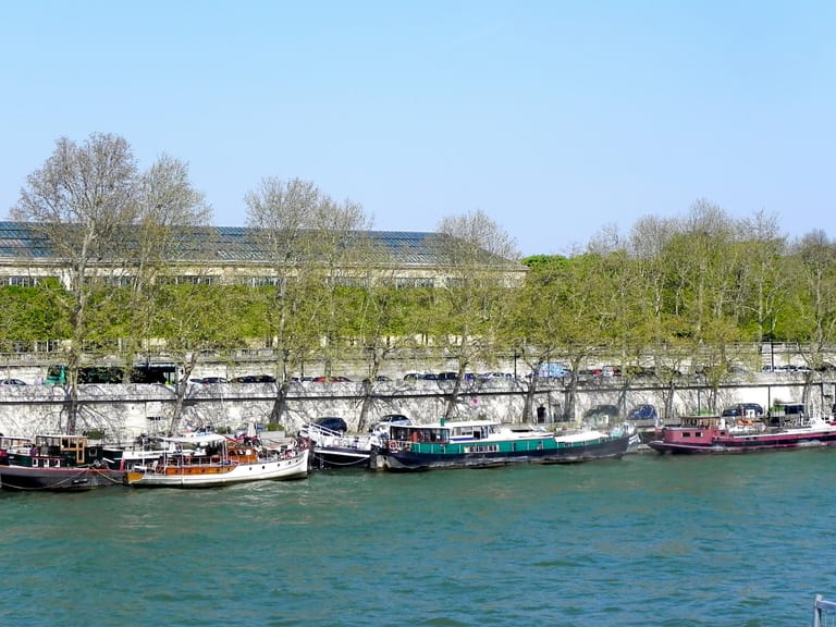 An der Seine ankern bunte Hausboote.