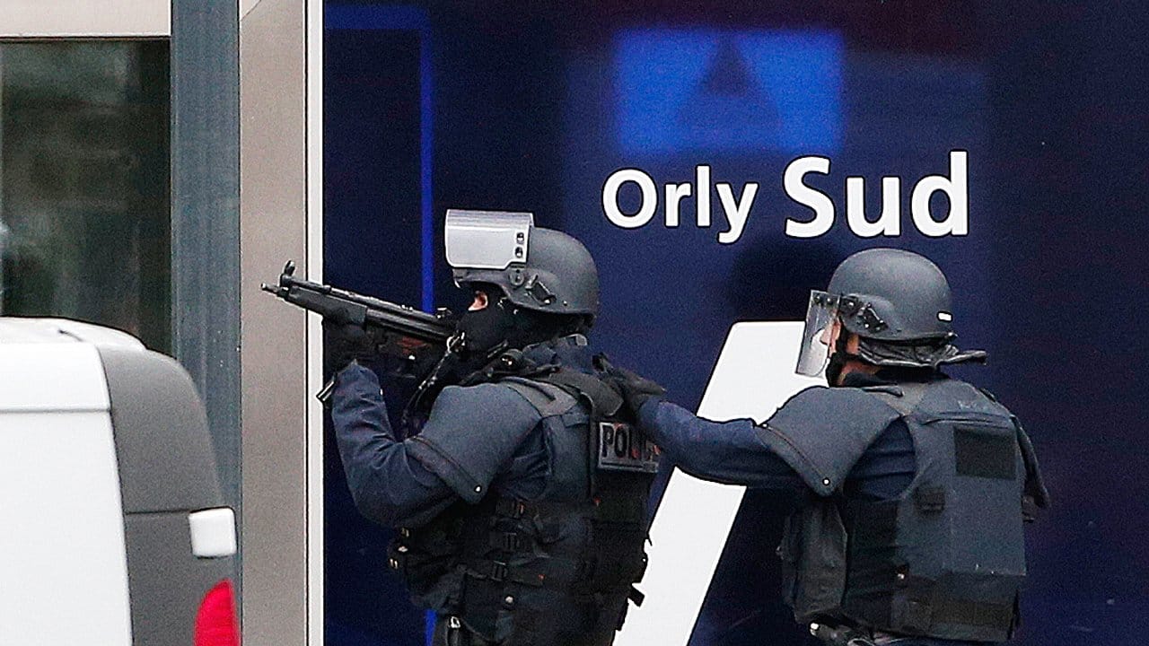 Spezialkräfte der französischen Polizei betreten mit der Waffe im Anschlag ein Terminal des Flughafens.