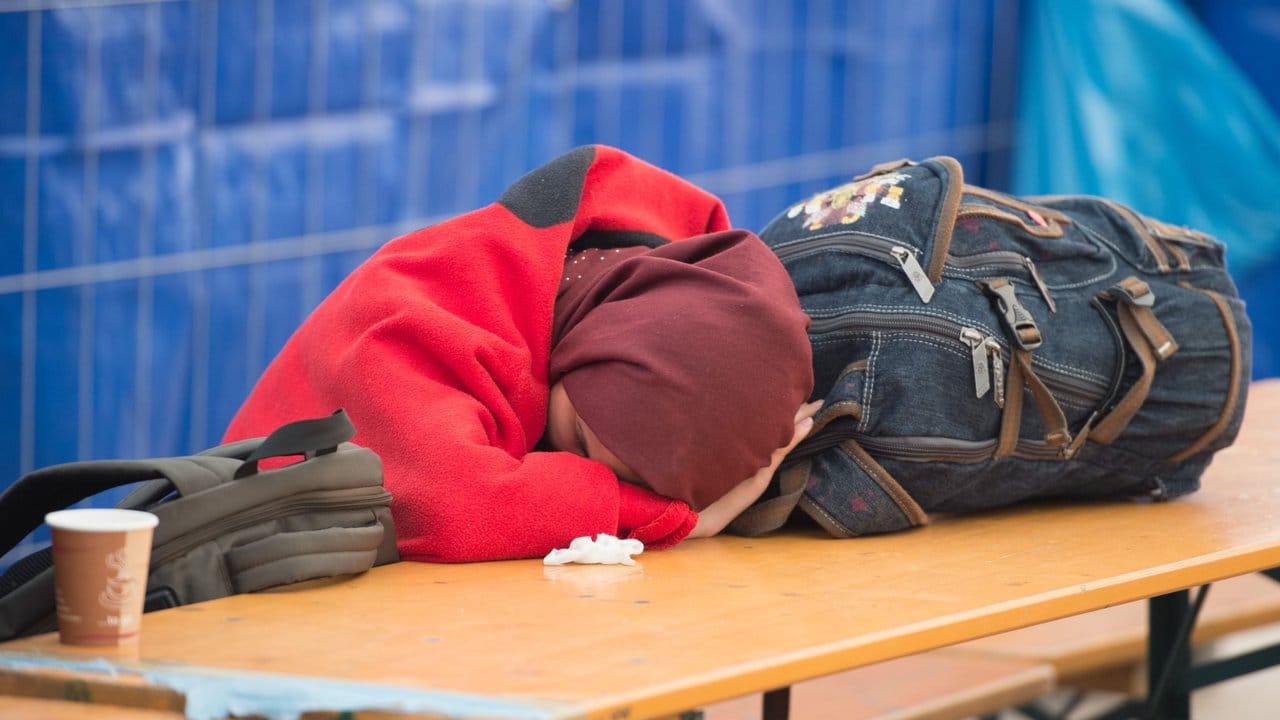 Eine Frau schläft nach der Überquerung der österreichisch-deutschen Grenze in einer Versorgungsstation für Flüchtlinge.