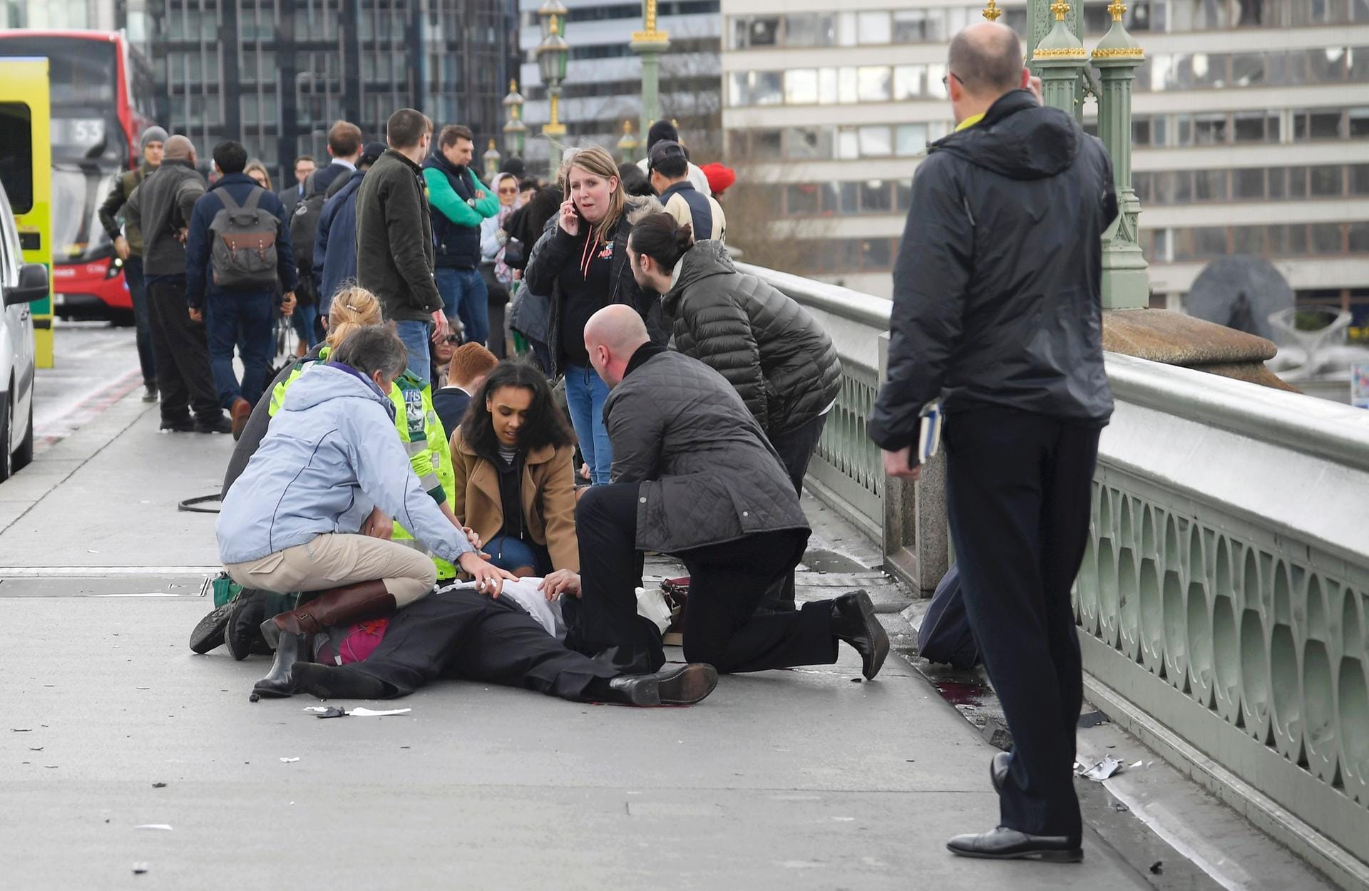 Erstversorgung: Passanten kümmern sich auf der Westminster Bridge in London um einen Verletzten. Auf der Brücke über die Themse war ein Auto in Fußgänger gefahren.