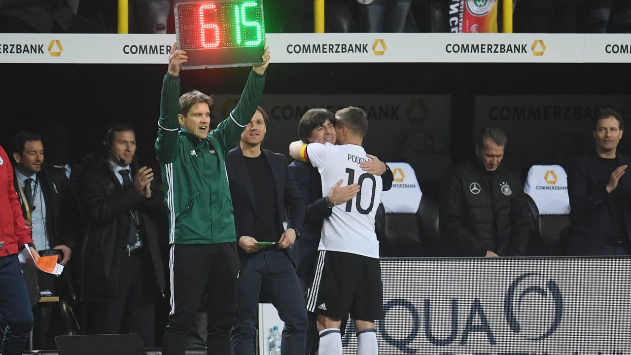 Bundestrainer Joachim Löw umarmt Lukas Podolski bei der Auswechslung.