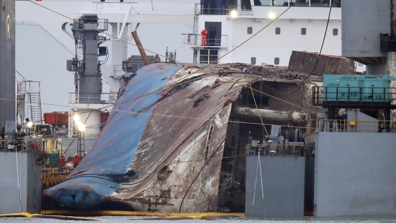Das Wrack der Fähre "Sewol" wird an der Küste vor Jindo auf ein Schwergutschiff gehoben. Das Wrack der Fähre "Sewol" wird an der Küste vor Jindo auf ein Schwergutschiff gehoben.