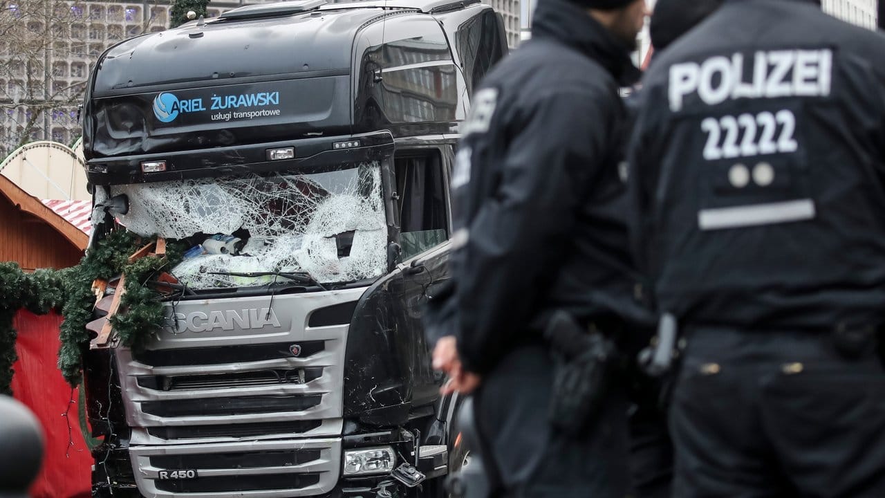 Polizisten stehen vor dem zerstörten LKW am 20. Polizisten stehen vor dem zerstörten LKW am 20.