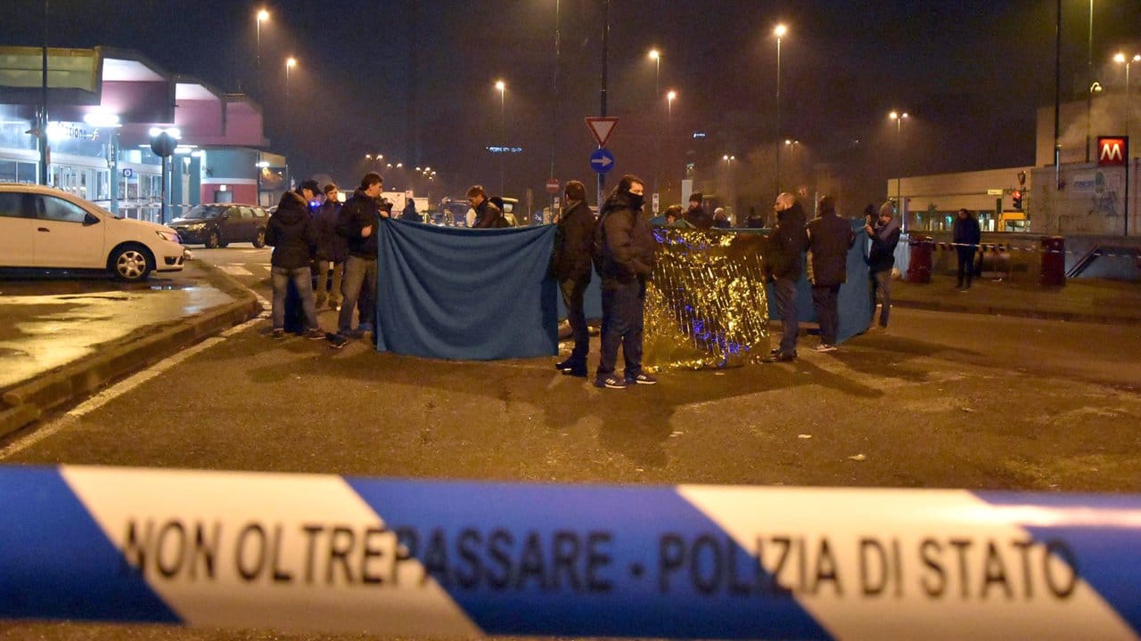 Hier starb Anis Amri: Polizisten schirmen nach der Schießerei in Sesto San Giovanni bei Mailand einen Leichnam ab. Hier starb Anis Amri: Polizisten schirmen nach der Schießerei in Sesto San Giovanni bei Mailand einen Leichnam ab.