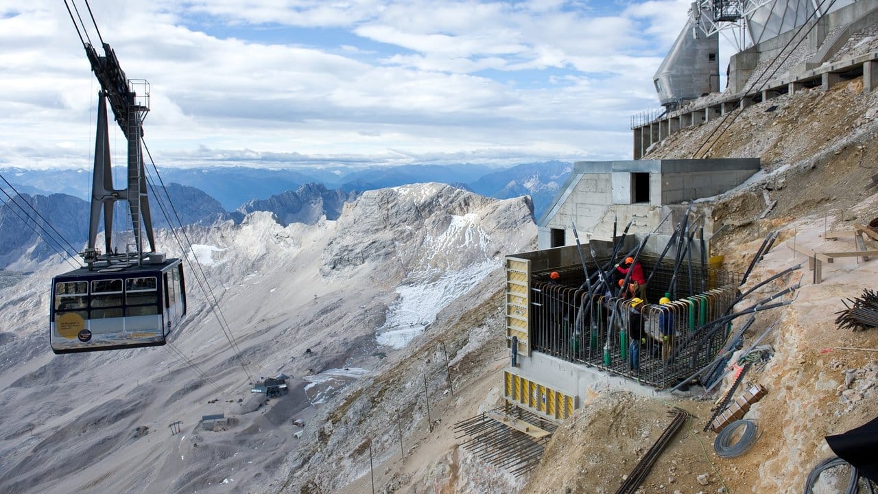 Während der Bauzeit: Die alte Gletscherseilbahn fährt auf der Zugspitze an den Bauarbeiten für ein neues Fundament vorbei.