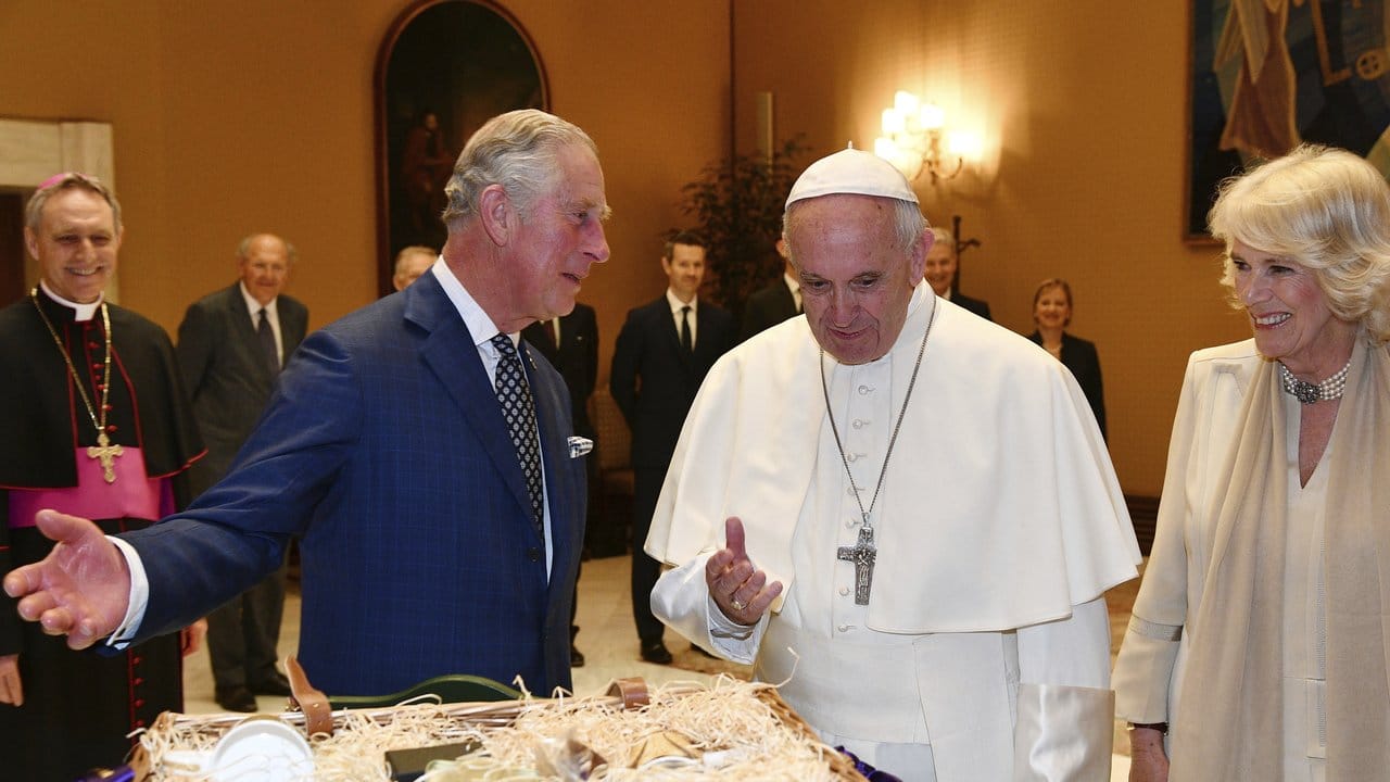 Papst Franziskus (M) tauscht einer Privataudienz im Vatikan Geschenke aus mit Prinz Charles (l) und seiner Frau Camilla.