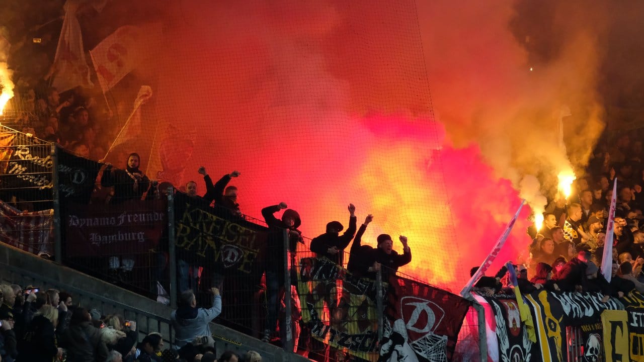 Dresdens Fans brennen im Stadion bengalische Feuer ab.