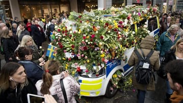 Ein Polizeifahrzeug ist in der Innenstadt von Stockholm nach dem Terroranschlag fast vollständig mit Blumen bedeckt.