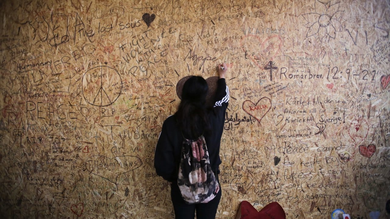 Eine Frau schreibt eine Botschaft auf eine Holzwand.