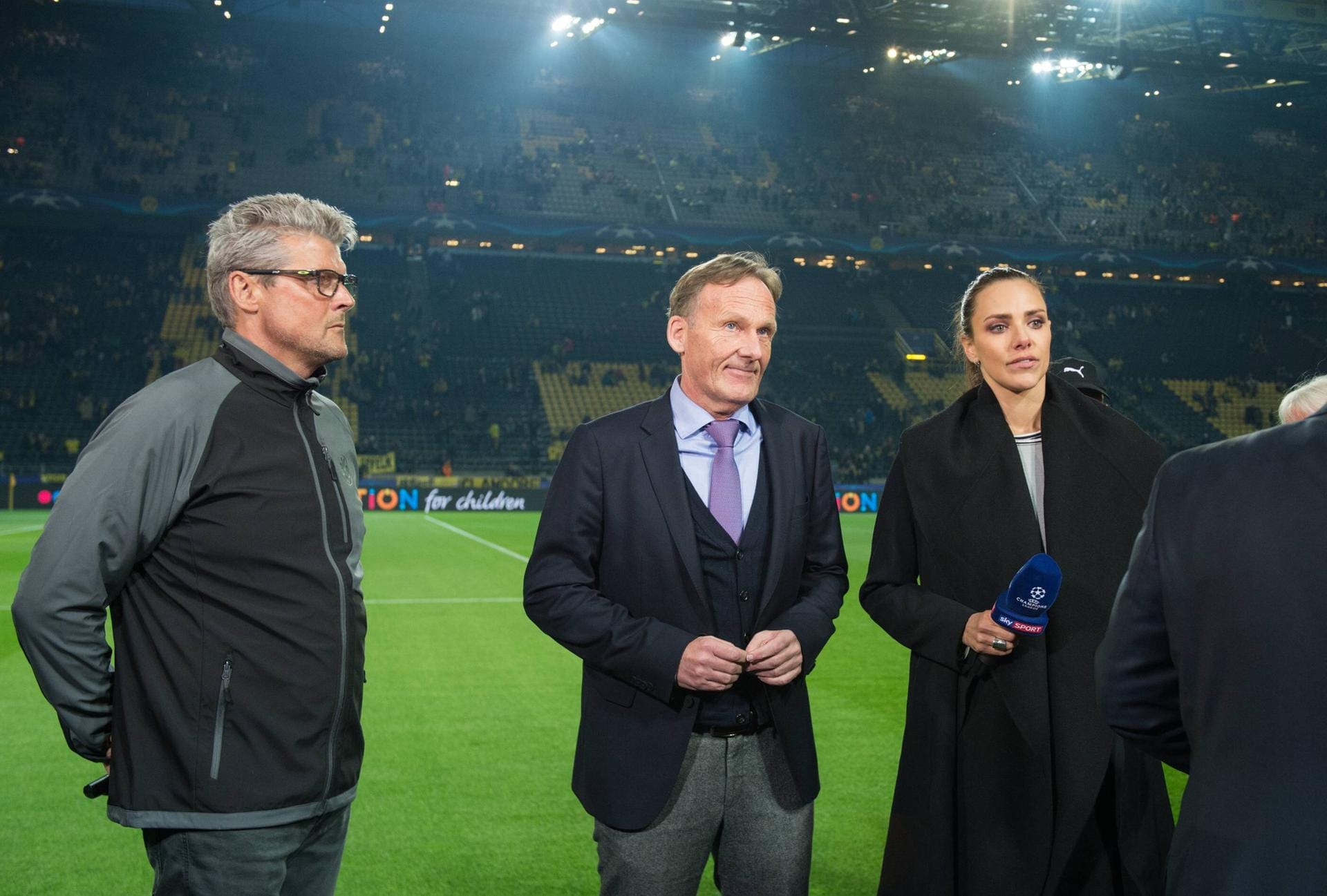 BVB-Stadionsprecher Norbert Dickel (l) und Hans-Joachim Watzke (BVB-Geschaeftsfuehrer) stehen am Spielfeldrand bei einem Fernsehinterview. Sie erklären auch die Spielabsage im Stadion.