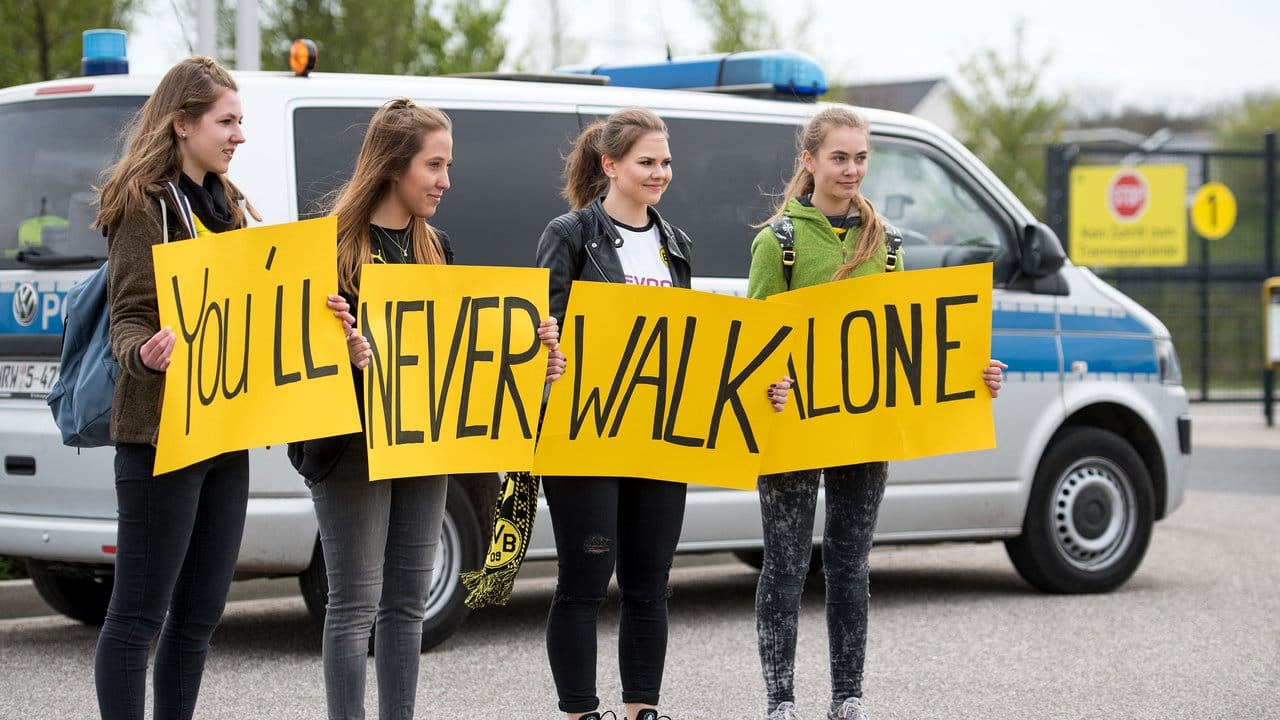 Fans halten vor dem Trainingsgelände von Borussia Dortmund Schilder mit der Aufschrift "You'll never walk alone".