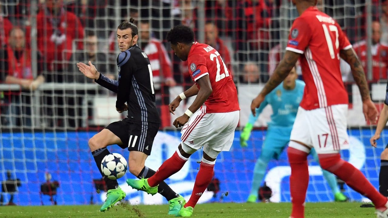 Real Madrids Gareth Bale (l) verhindert einen Schuss aufs Tor von David Alaba (M).