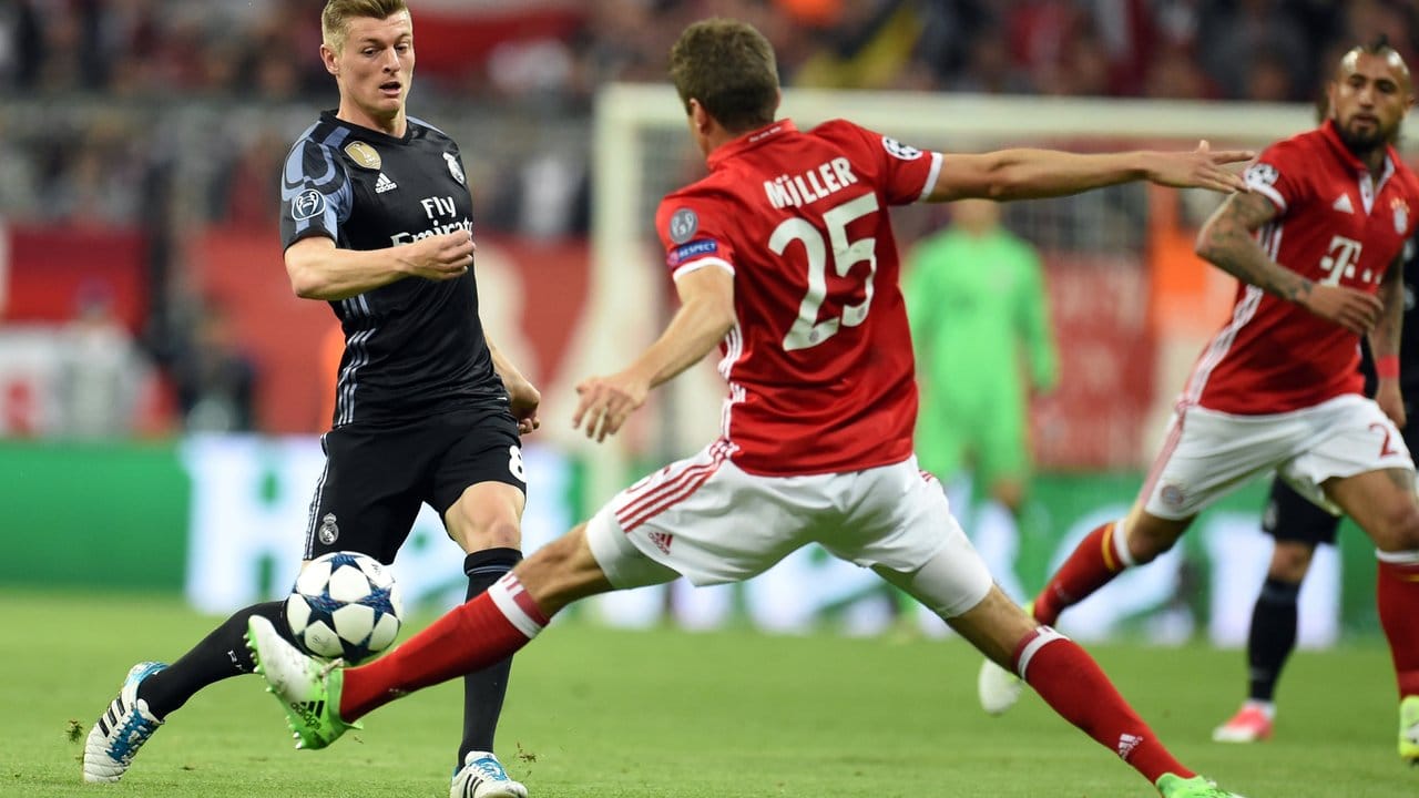 Thomas Müller (25) fängt einen Pass von Real-Spieler Toni Kroos (l) ab.