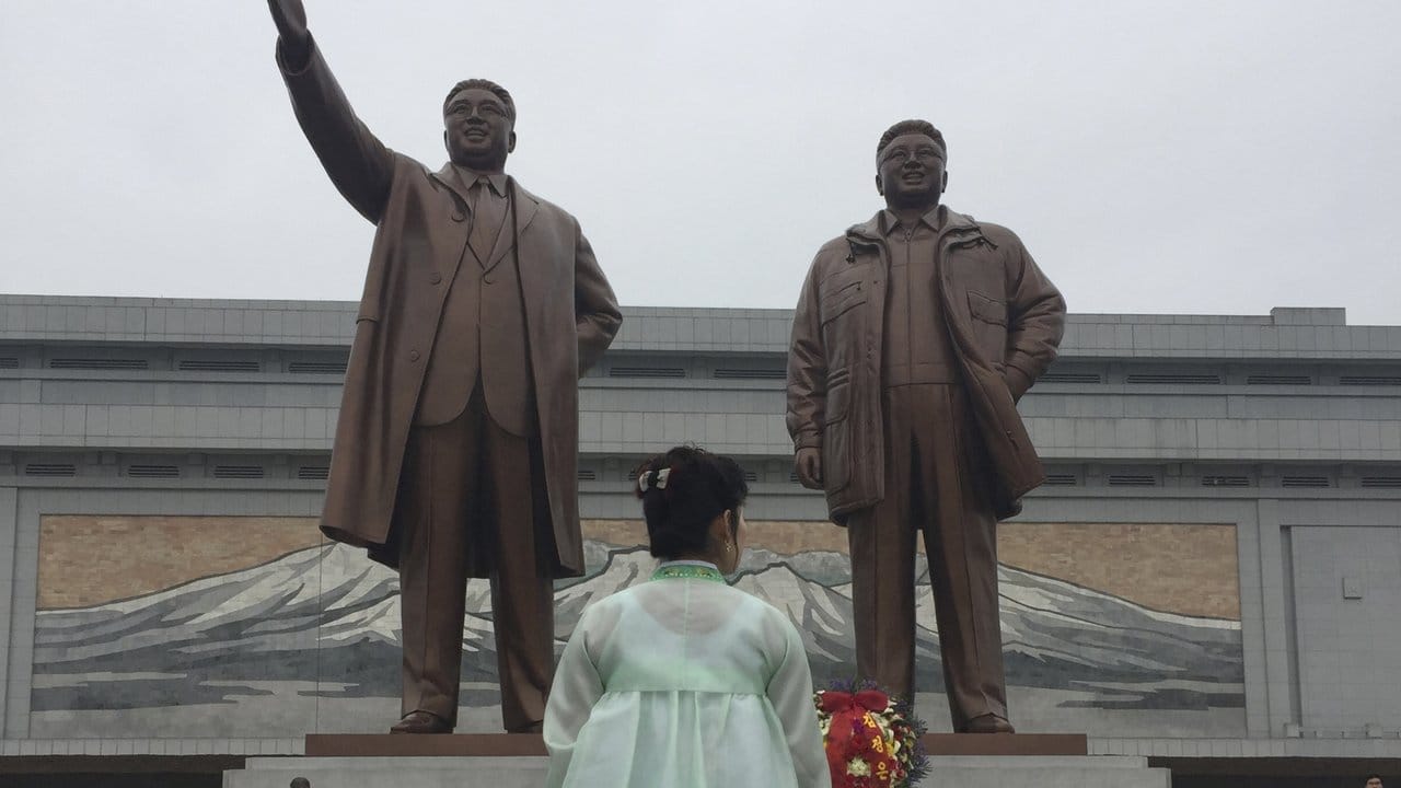 Eine Frau steht festlich gekleidet in Pjöngjang vor den Statuen der beiden ehemaligen Machthaber Kim Il Sung (l) und Kim Jong Il (r). Eine Frau steht festlich gekleidet in Pjöngjang vor den Statuen der beiden ehemaligen Machthaber Kim Il Sung (l) und Kim Jong Il (r).