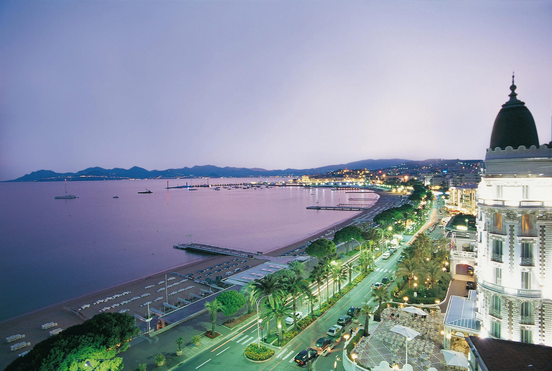 Die Uferpromenade in Cannes ist gesäumt von hohen Palmen, gepflegten Parkanlagen und historischen Palästen.