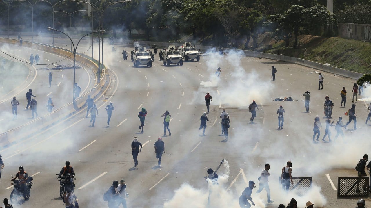 Über der Route der Demonstranten in Caracas liegen Tränengaswolken.
