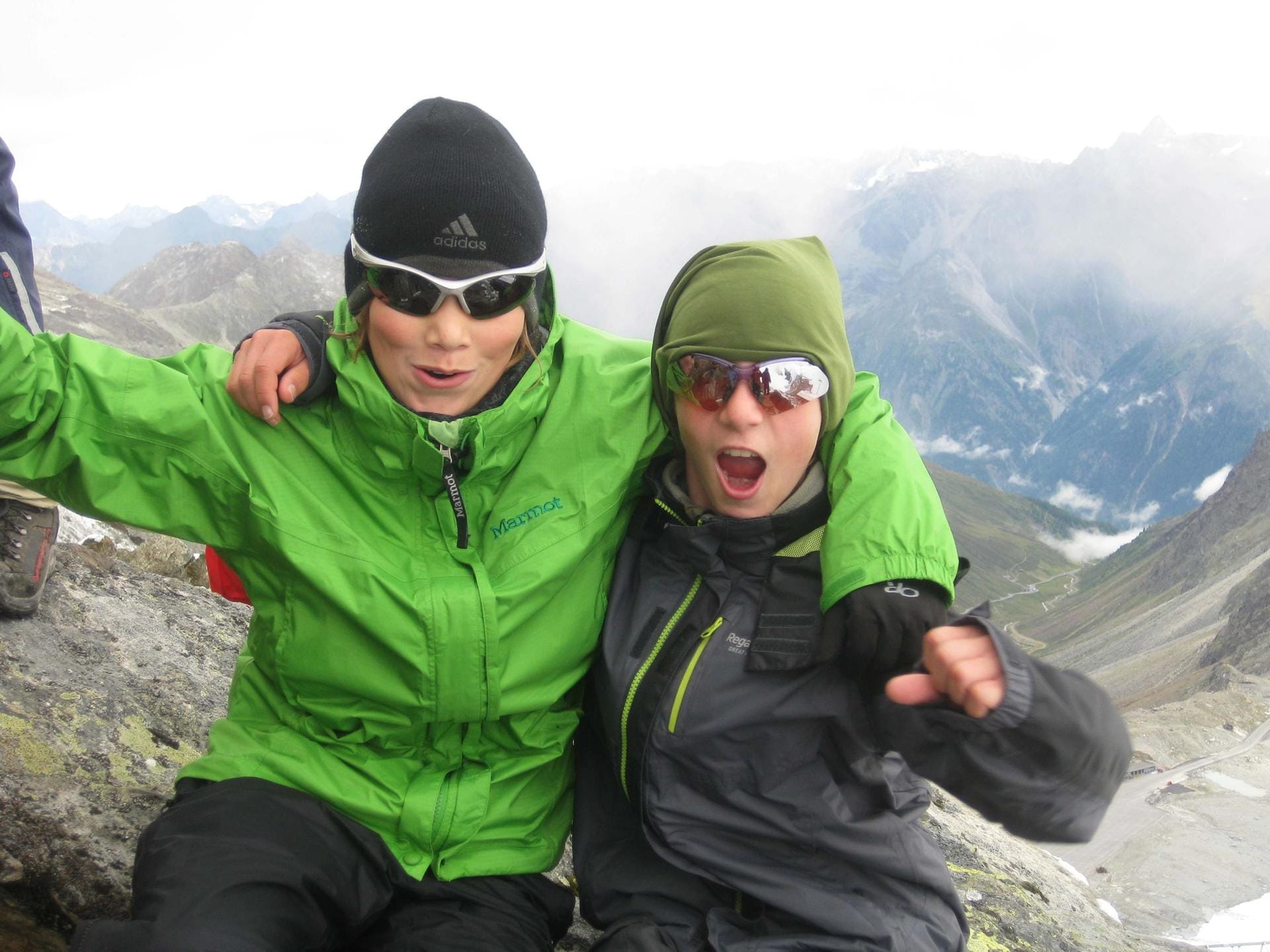 Zwei Jugendliche am Gipfel bei der Alpenüberquerung.
