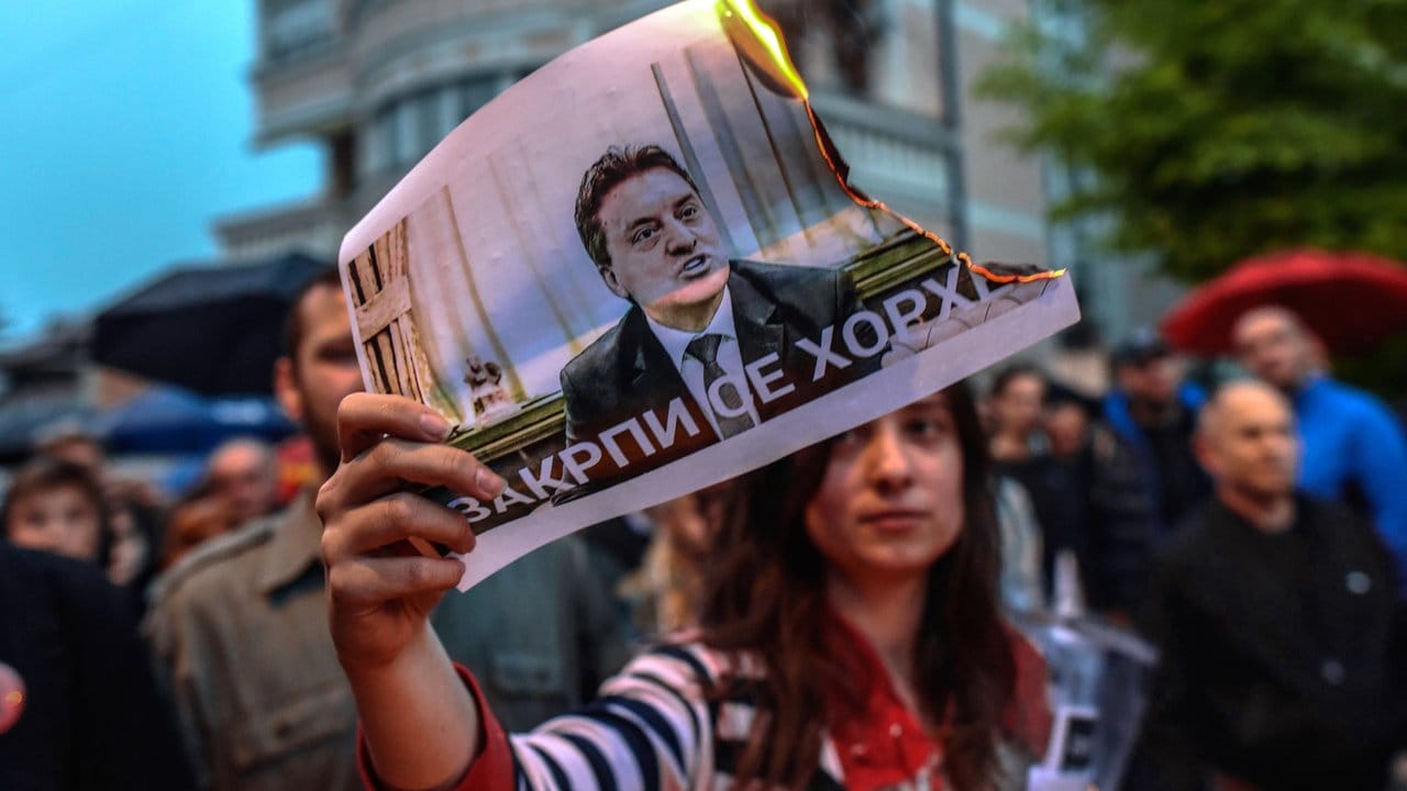 Eine Demonstrantin verbrennt während eines Protestmarsches in Skopje ein Foto des Staatsoberhaupts Djordje Ivanov.