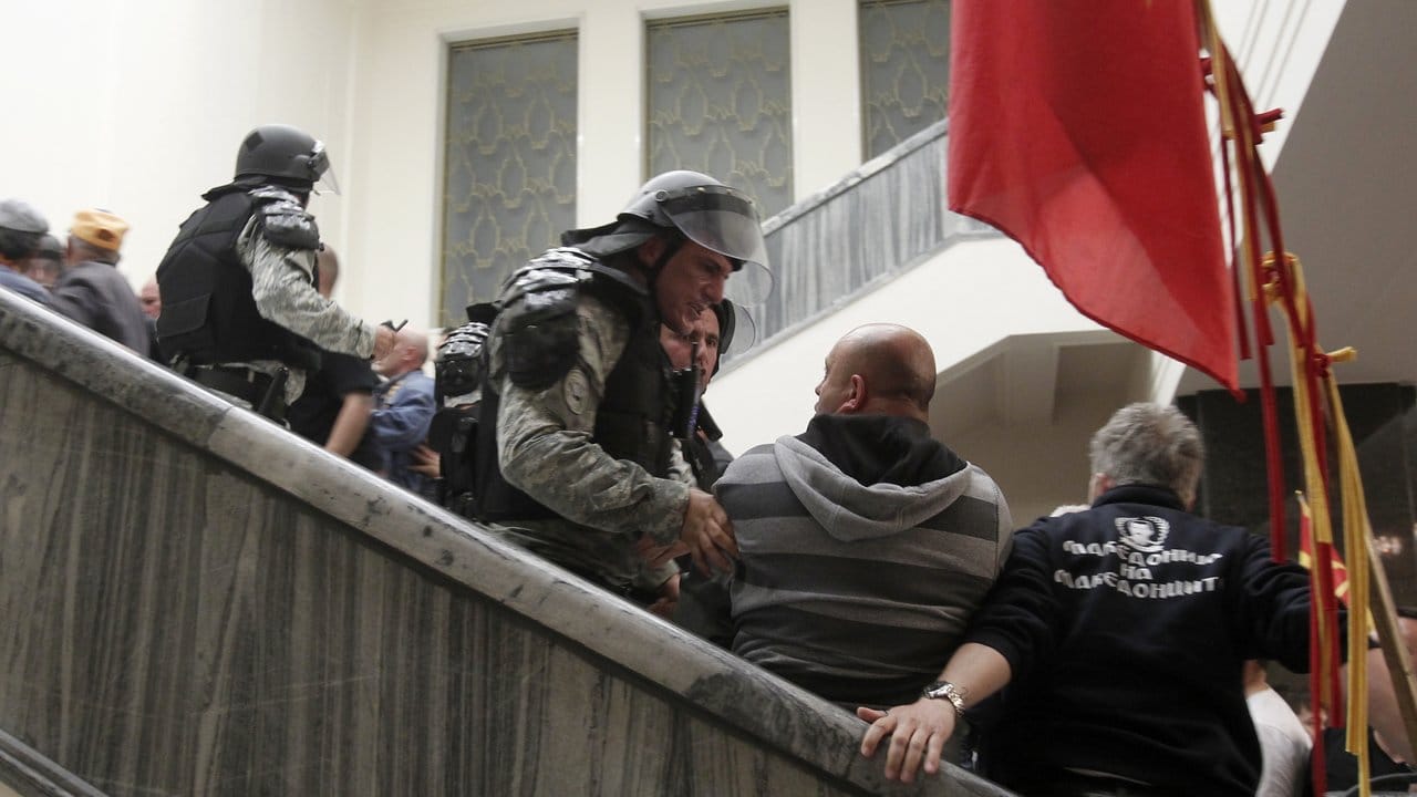 Polizisten drängen im mazedonischen Parlament in Skopje Menschen von der Treppe.